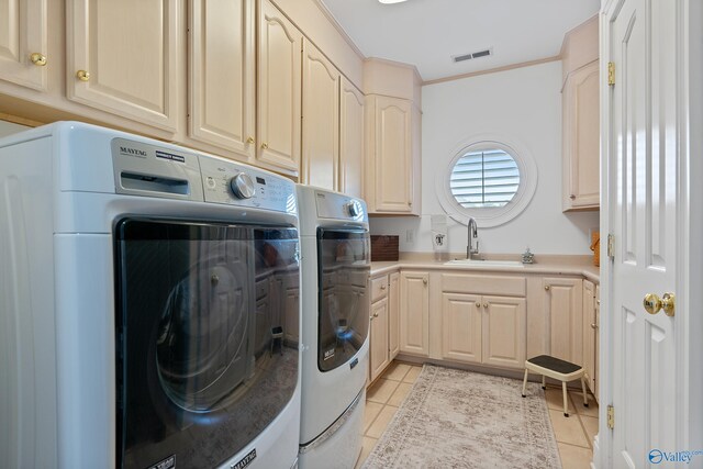 clothes washing area featuring washer and dryer, cabinet space, light tile patterned floors, and ornamental molding