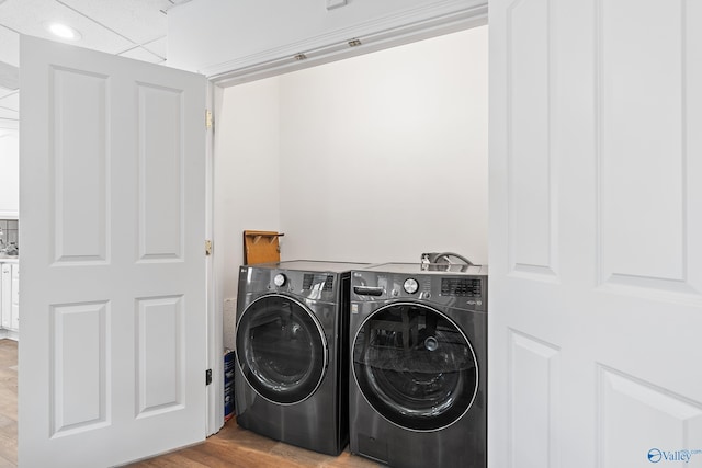 washroom with washing machine and dryer and wood finished floors