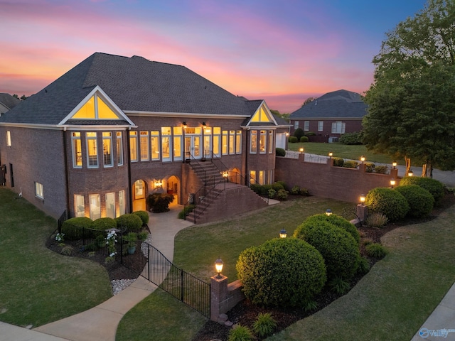rear view of house featuring stairway, a shingled roof, and curved driveway