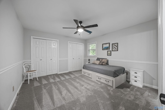 carpeted bedroom featuring baseboards, ceiling fan, and two closets
