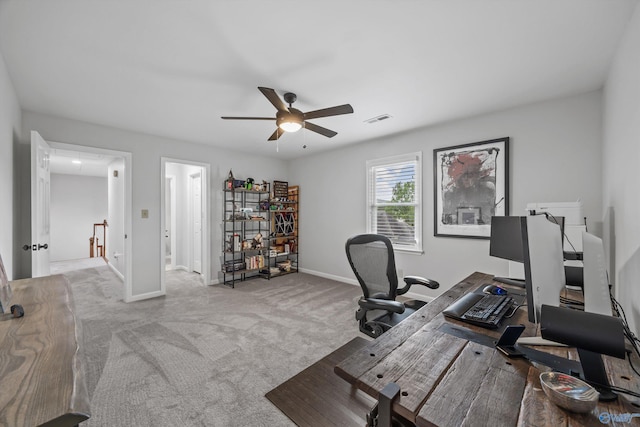 carpeted office featuring baseboards, ceiling fan, attic access, and visible vents