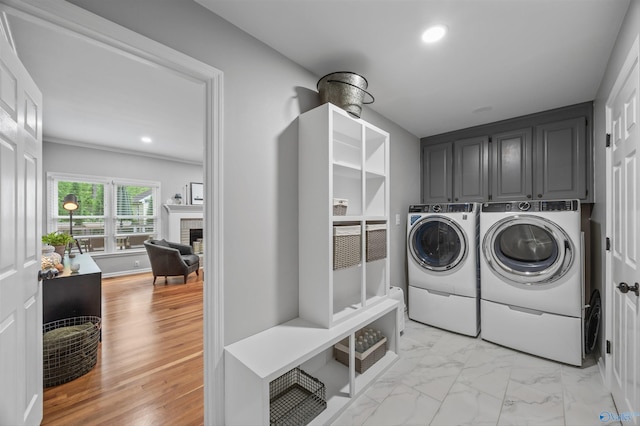 laundry room featuring separate washer and dryer, recessed lighting, cabinet space, and a fireplace