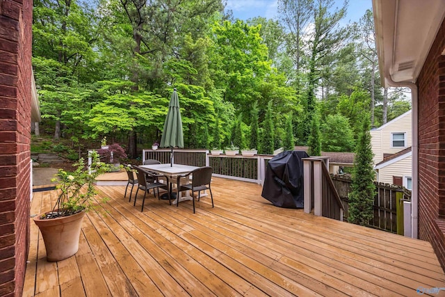 wooden terrace with outdoor dining area and area for grilling