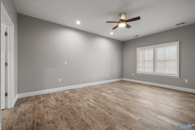 spare room with visible vents, baseboards, a ceiling fan, and wood finished floors