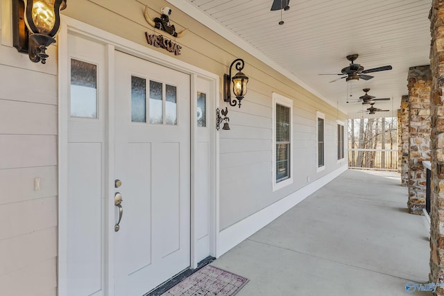 entrance to property featuring a porch and ceiling fan