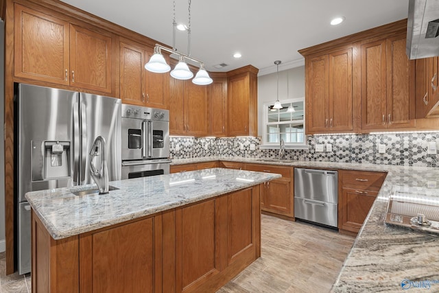 kitchen with light stone countertops, brown cabinetry, and appliances with stainless steel finishes