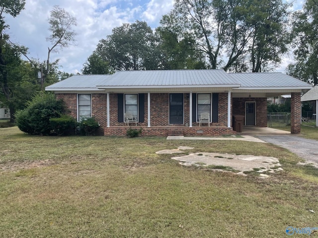 ranch-style home with a front lawn, brick siding, driveway, and metal roof