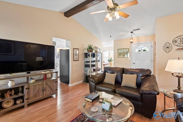 living room featuring vaulted ceiling with beams, ceiling fan, and light wood-type flooring