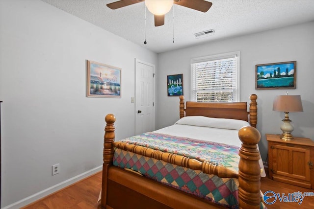 bedroom with wood-type flooring, a textured ceiling, and ceiling fan