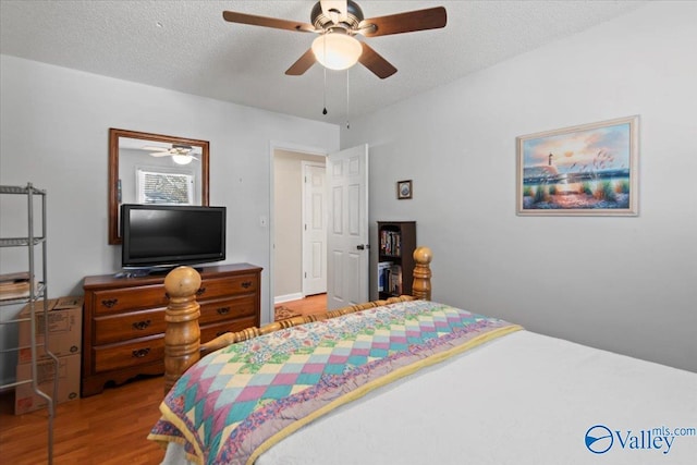 bedroom featuring ceiling fan, a textured ceiling, and light wood-type flooring