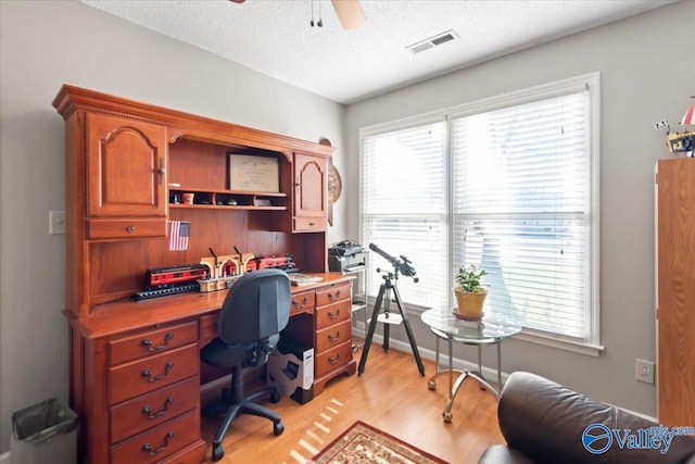 office with ceiling fan, a textured ceiling, and light wood-type flooring