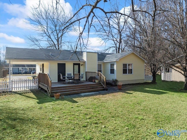 rear view of house featuring a lawn and a deck