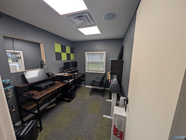 carpeted office featuring baseboards, visible vents, and a paneled ceiling