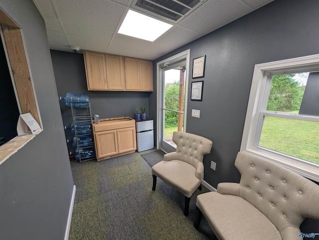 sitting room featuring baseboards, visible vents, and a paneled ceiling