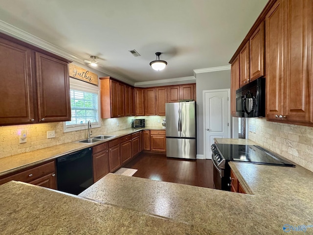 kitchen featuring dark wood-style floors, visible vents, a sink, crown molding, and black appliances