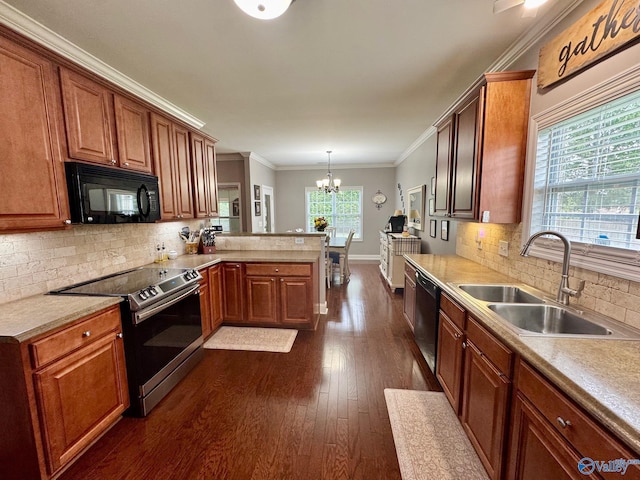 kitchen featuring a sink, black appliances, a chandelier, a peninsula, and dark wood-style floors