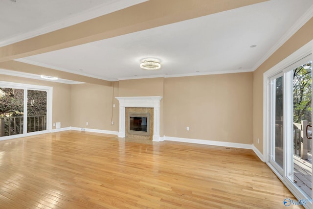 unfurnished living room featuring light wood-type flooring, crown molding, and a premium fireplace