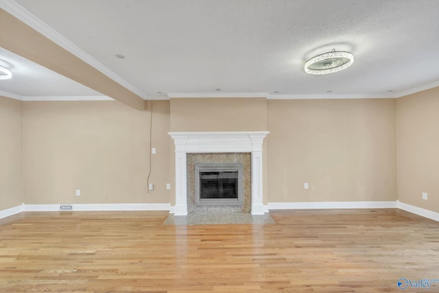 unfurnished living room featuring a fireplace, light hardwood / wood-style flooring, a textured ceiling, and ornamental molding