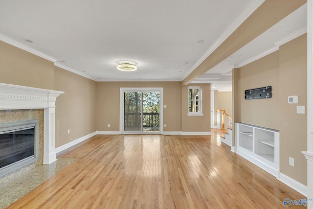 unfurnished living room featuring light hardwood / wood-style floors, crown molding, and a premium fireplace