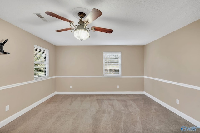 empty room with light carpet, a textured ceiling, and ceiling fan