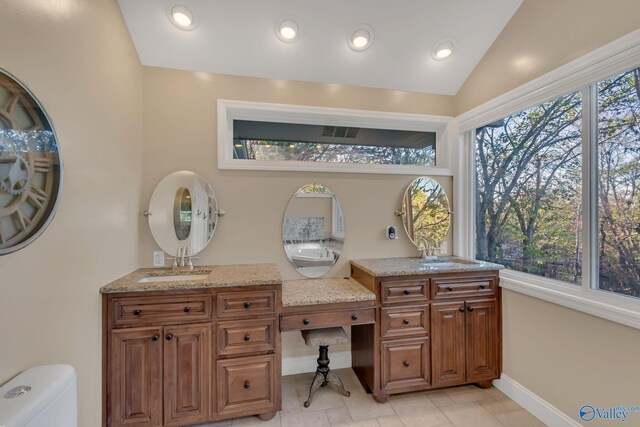 bathroom with vanity, toilet, and lofted ceiling