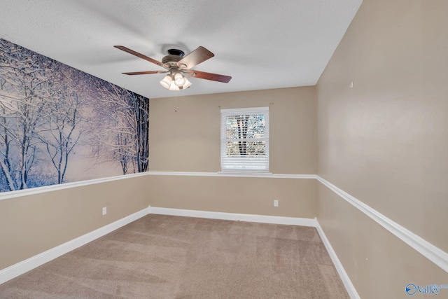 carpeted spare room featuring ceiling fan and a textured ceiling