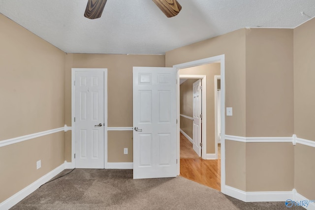 unfurnished bedroom featuring ceiling fan, carpet, and a textured ceiling