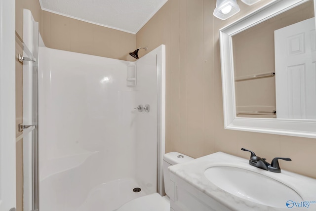 bathroom featuring a textured ceiling, toilet, walk in shower, and crown molding