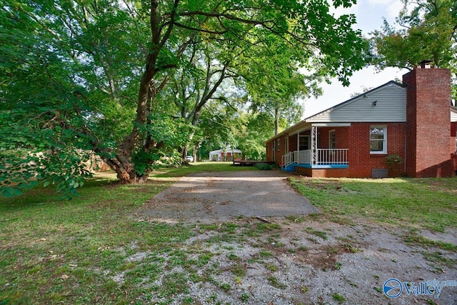 view of yard with a porch and driveway