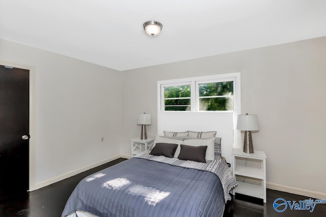 bedroom featuring wood finished floors and baseboards