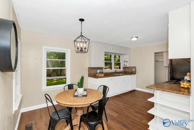 dining space featuring a notable chandelier, visible vents, dark wood-type flooring, and baseboards