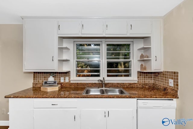 bar featuring dishwasher, backsplash, and a sink