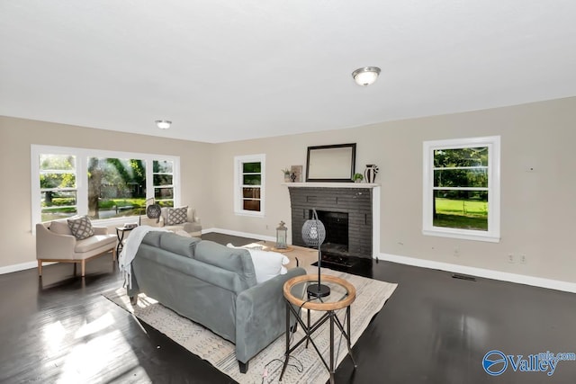 living room featuring a brick fireplace, visible vents, and baseboards