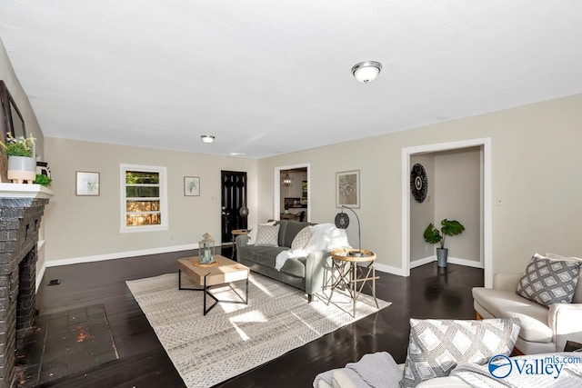 living area with wood finished floors, a fireplace, and baseboards