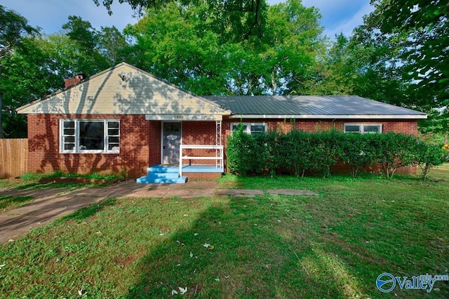 single story home with brick siding, a front lawn, and fence