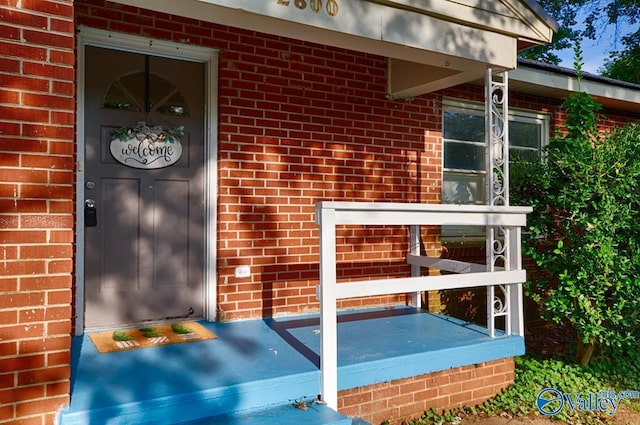 entrance to property featuring brick siding