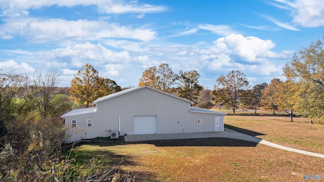 view of side of property with a garage, an outdoor structure, and a lawn