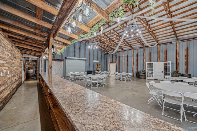 misc room featuring concrete flooring, beam ceiling, and high vaulted ceiling