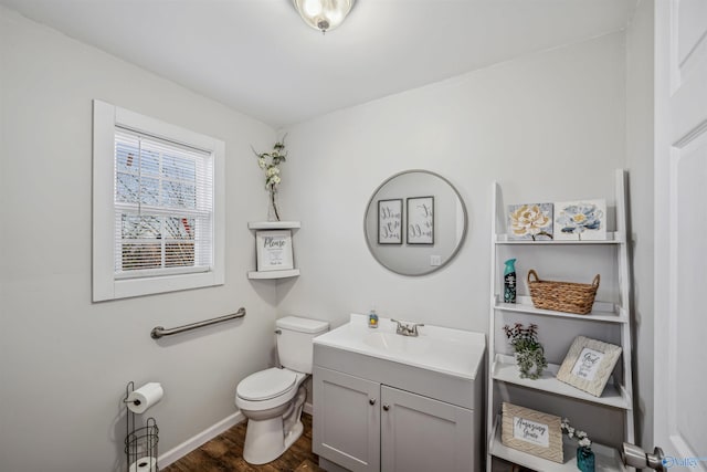 bathroom with toilet, vanity, and hardwood / wood-style flooring