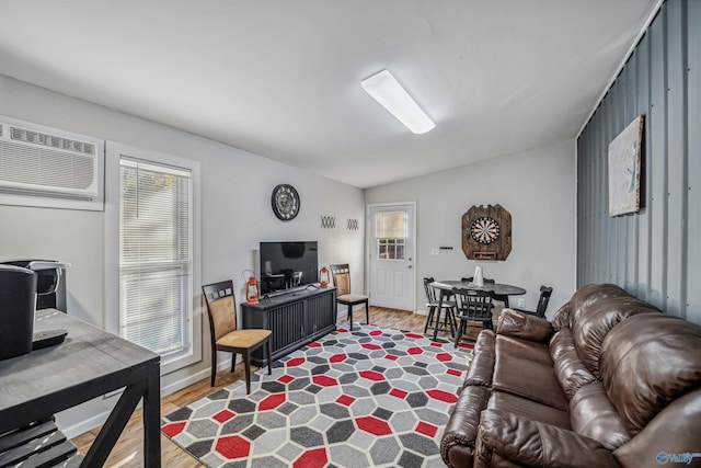 living room featuring a wall mounted AC, hardwood / wood-style floors, and vaulted ceiling