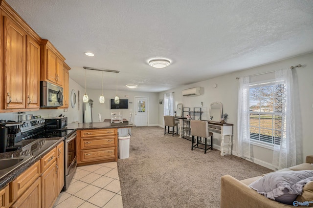 kitchen featuring a textured ceiling, stainless steel appliances, a wall mounted AC, decorative light fixtures, and light tile patterned flooring