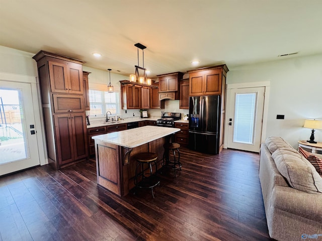 624 2nd Ave S, Loretto, TN 38469 - kitchen with black appliances, a kitchen breakfast bar, dark wood-style floors, open floor plan, and decorative light fixtures