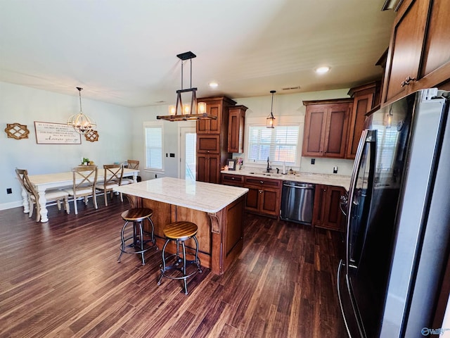 624 2nd Ave S, Loretto, TN 38469 - kitchen featuring freestanding refrigerator, stainless steel dishwasher, dark wood-style floors, a breakfast bar, and pendant lighting