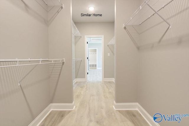 walk in closet with hardwood / wood-style floors