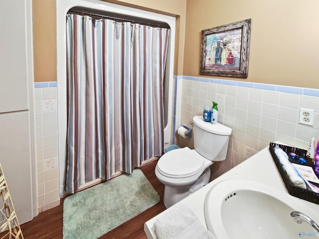 bathroom with walk in shower, toilet, wood-type flooring, tile walls, and vanity