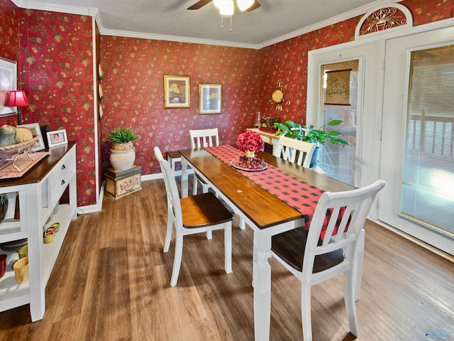 dining room with hardwood / wood-style floors, a textured ceiling, ornamental molding, and ceiling fan