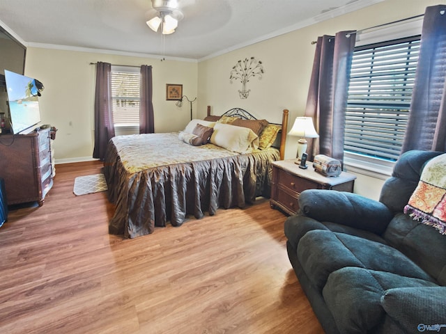 bedroom with crown molding, ceiling fan, and light hardwood / wood-style flooring