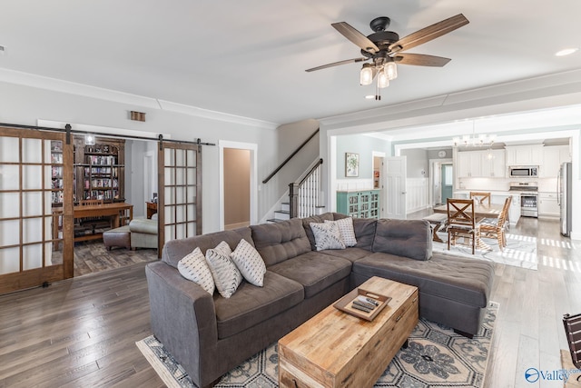 living room with french doors, dark hardwood / wood-style flooring, ceiling fan with notable chandelier, and ornamental molding