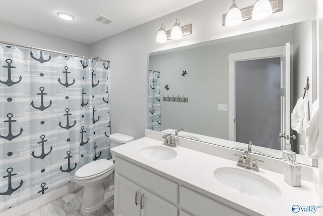 bathroom featuring vanity, toilet, and walk in shower