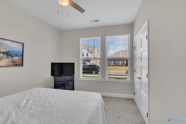 bedroom featuring light colored carpet, a closet, and ceiling fan